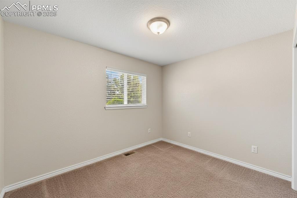 Image 19 of 48: Carpeted spare room featuring baseboards and a textured ceiling