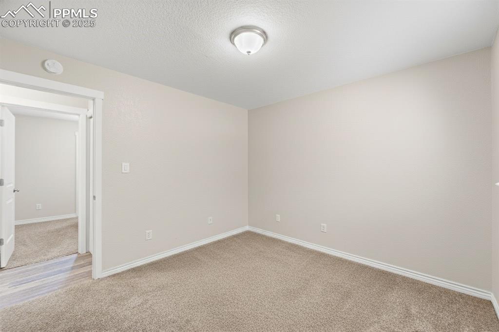 Image 21 of 48: Spare room featuring light carpet and a textured ceiling