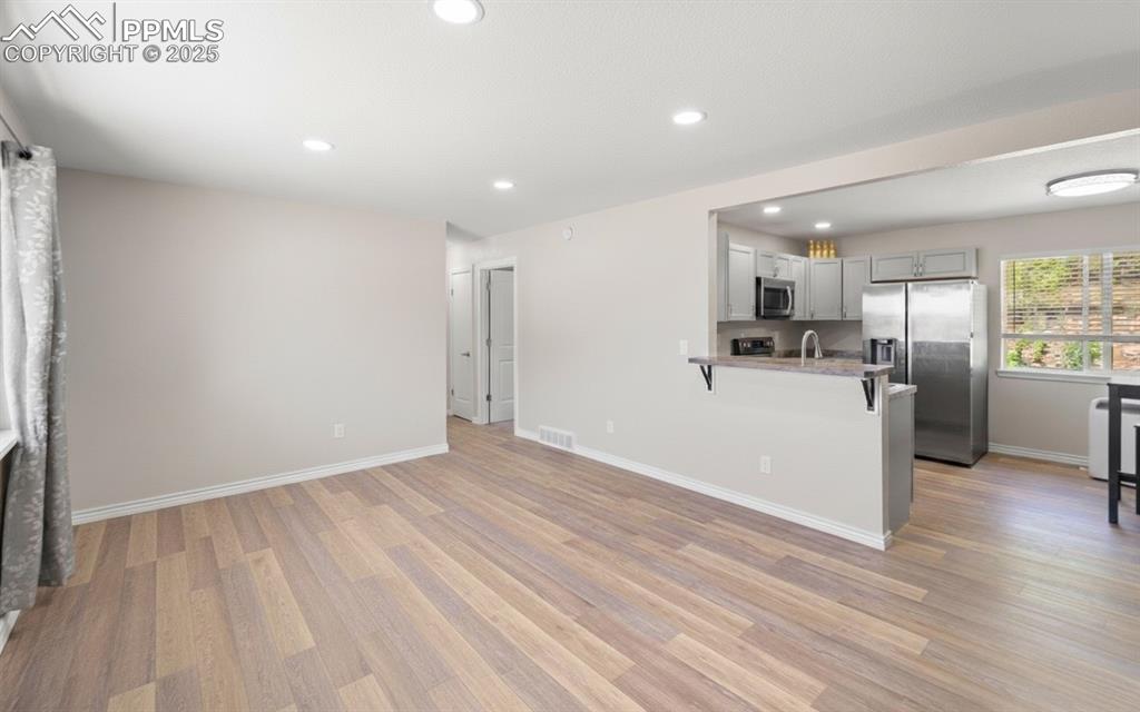 Image 7 of 48: Kitchen featuring gray cabinets, stainless steel appliances, a peninsula, l
