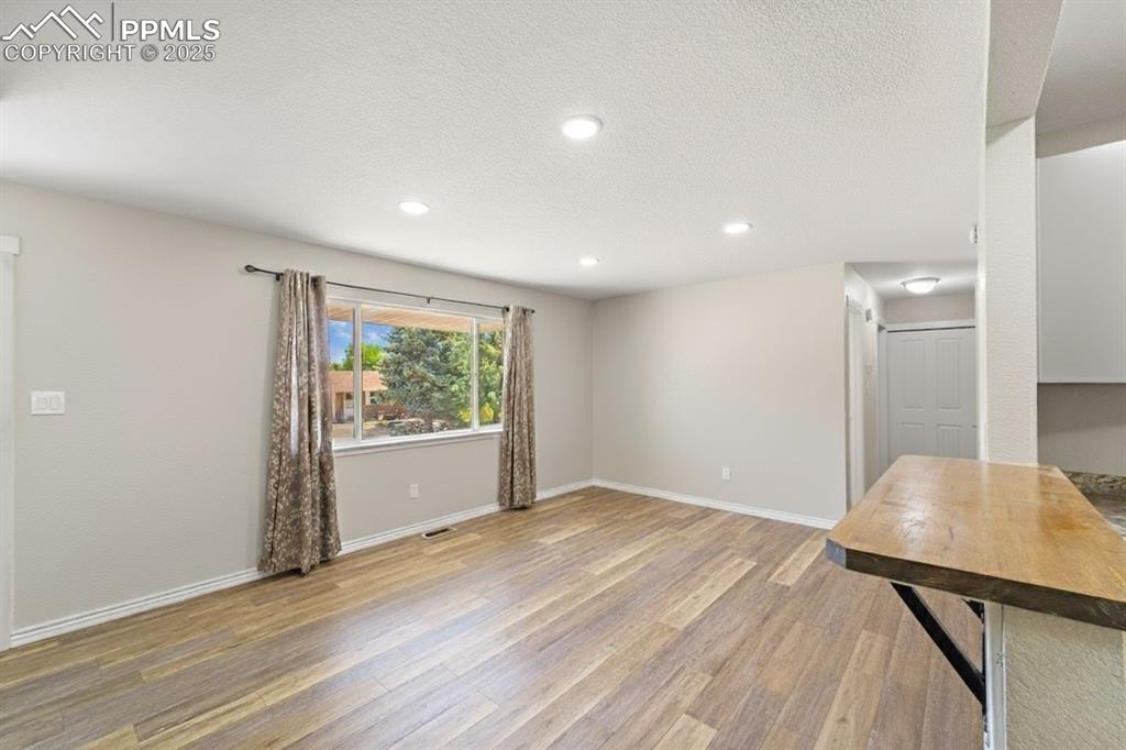 Image 8 of 48: Unfurnished living room with light wood-type flooring, recessed lighting, a
