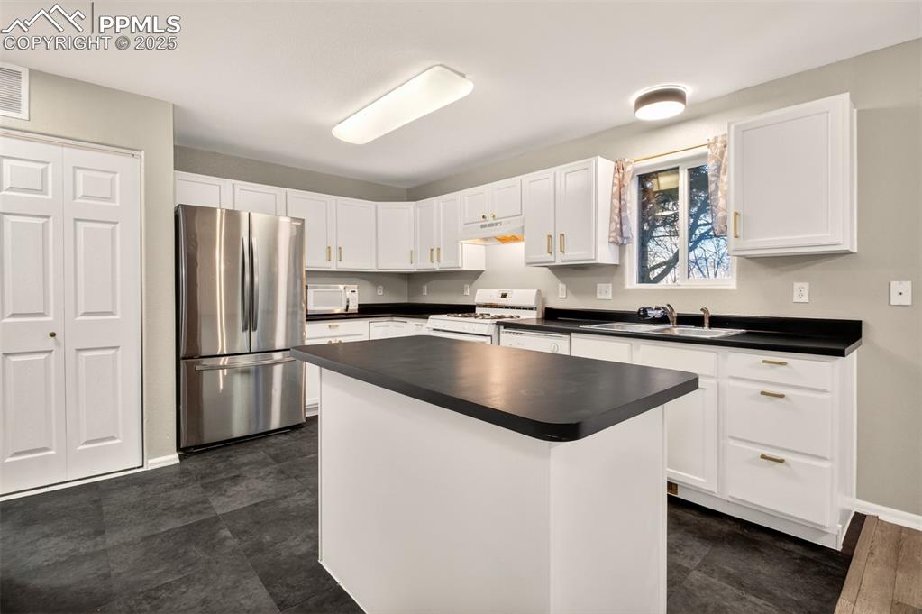 Image 7 of 24: Newer Stainless Steel refrigerator and new cabinet hardware.