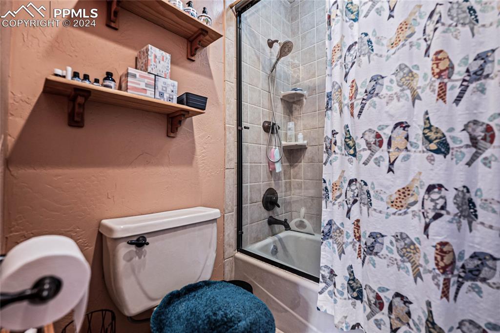 Image 22 of 48: Bathroom featuring shower / bath combination with curtain and toilet
