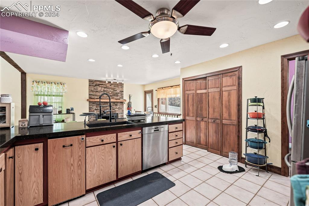 Image 30 of 48: Kitchen with ceiling fan, sink, a textured ceiling, light tile patterned fl