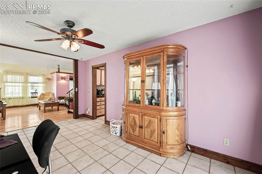 Image 34 of 48: Bonus room area featuring ceiling fan, light tile patterned floors, and a t