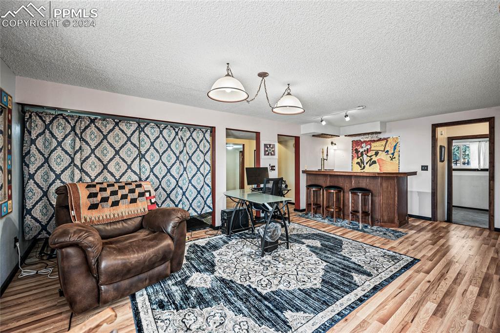 Image 42 of 48: Basement Living room featuring hardwood / wood-style floors, an AC wall uni