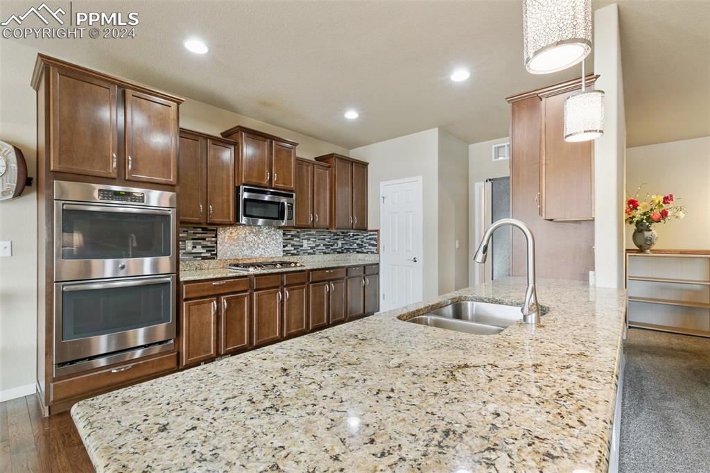Image 11 of 39: Kitchen with granite countertops, double ovens and pantry.