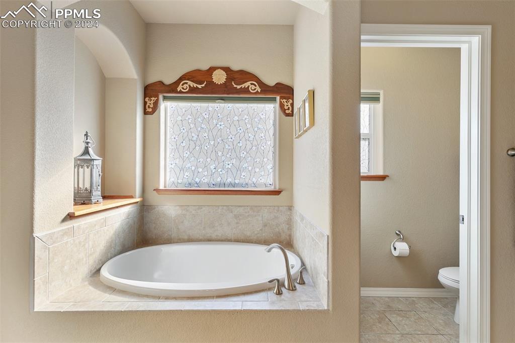 Image 18 of 39: Soaking tub with beautiful window and custom molding.
