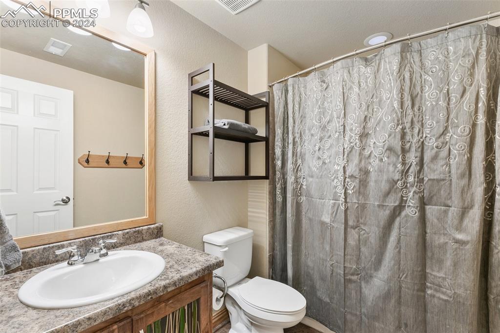 Image 34 of 39: Basement bath conveniently located between bedrooms.