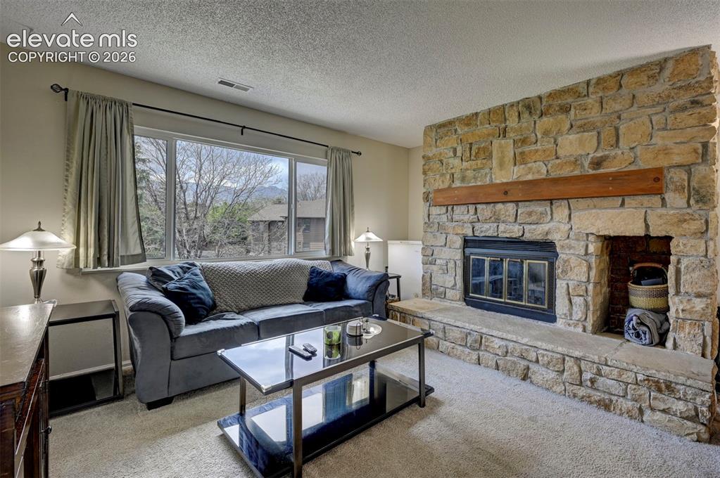 Image 5 of 25: Spacious Living Room, Features a Beautiful Masonry Wood Burning Fireplace f
