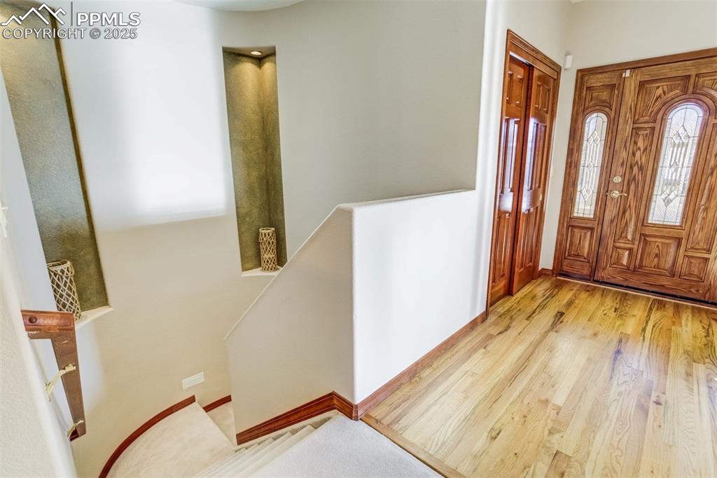 Image 31 of 49: Curved stairway with inset details lead to the finished basement
