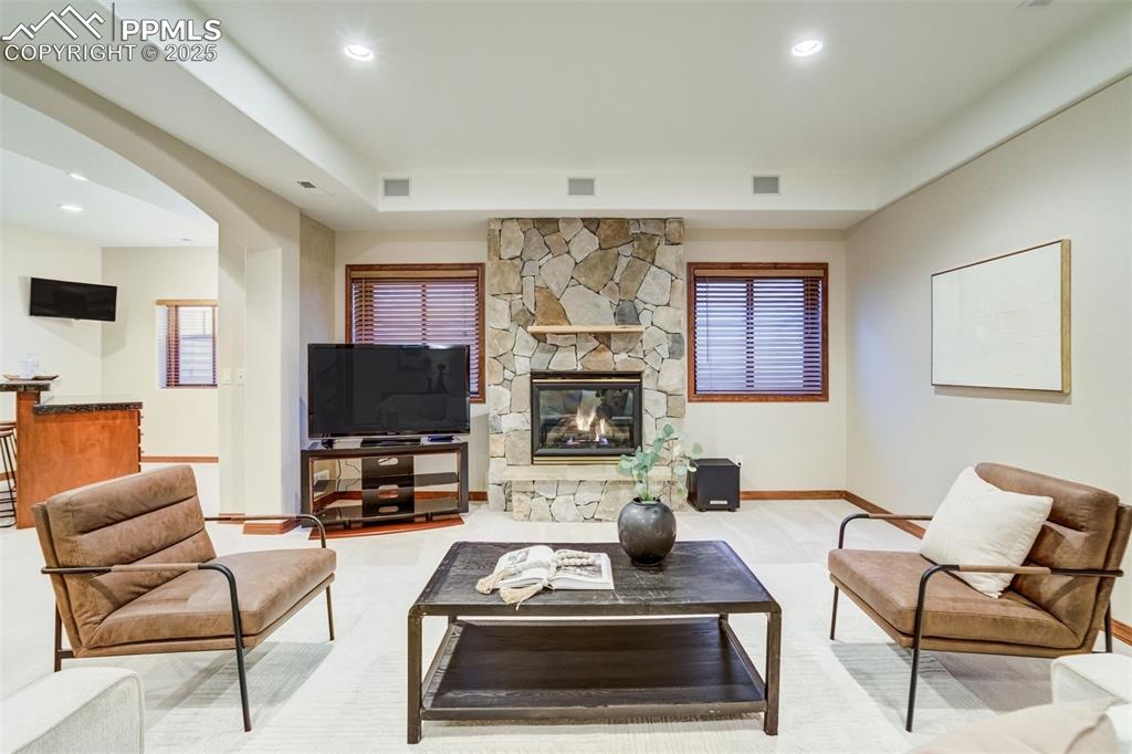 Image 33 of 49: Gas fireplace with stone surround in the basement.
