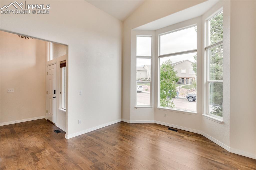 Image 13 of 35: Living room off of entry featuring soaring ceilings and extensive natural l
