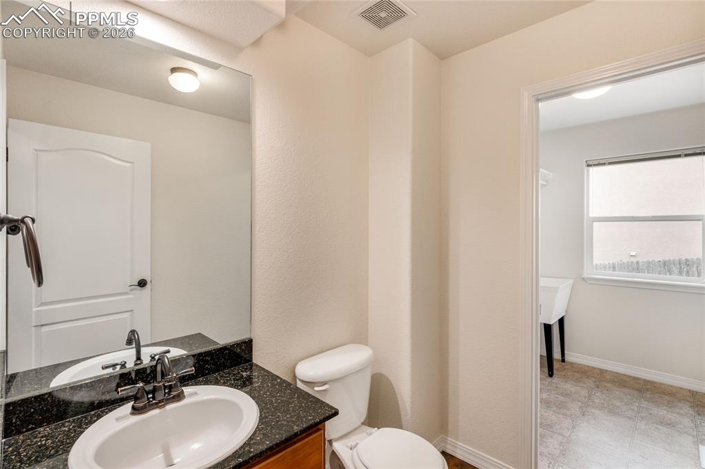 Image 14 of 35: Main floor half bathroom with attached laundry room.