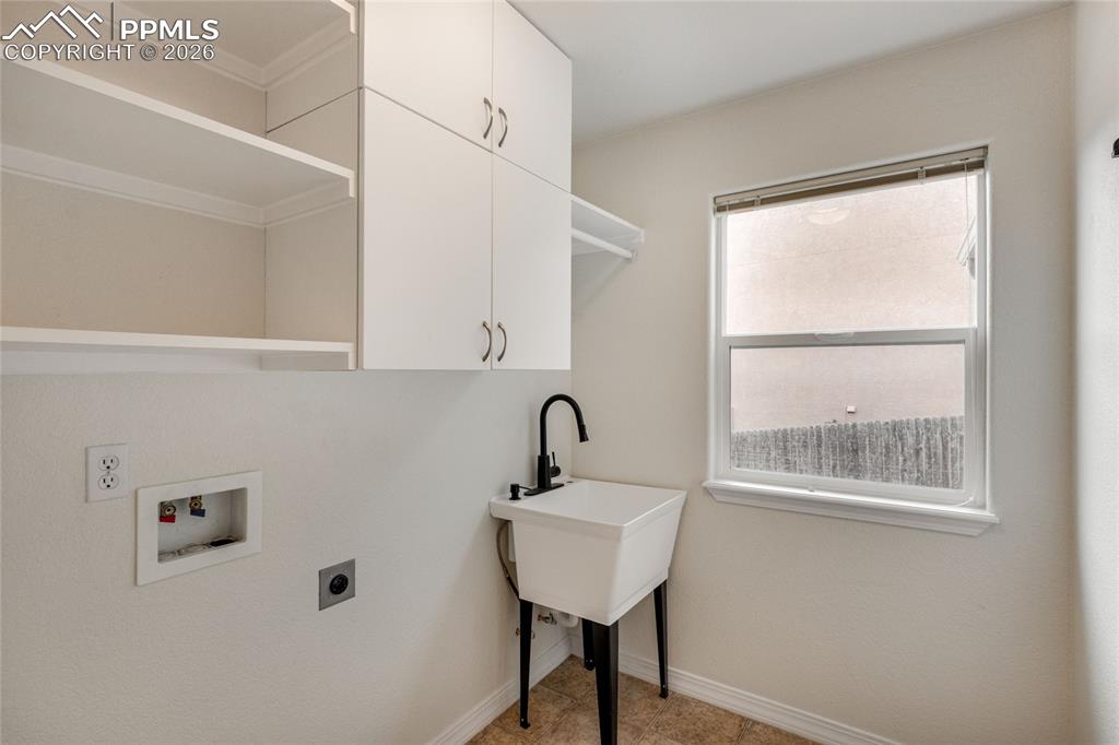 Image 15 of 35: Dedicated laundry space featuring a utility sink with a black gooseneck fau