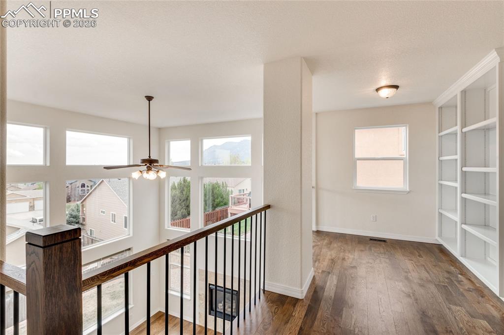 Image 17 of 35: Upper-level loft landing featuring wood-finish flooring and integrated buil