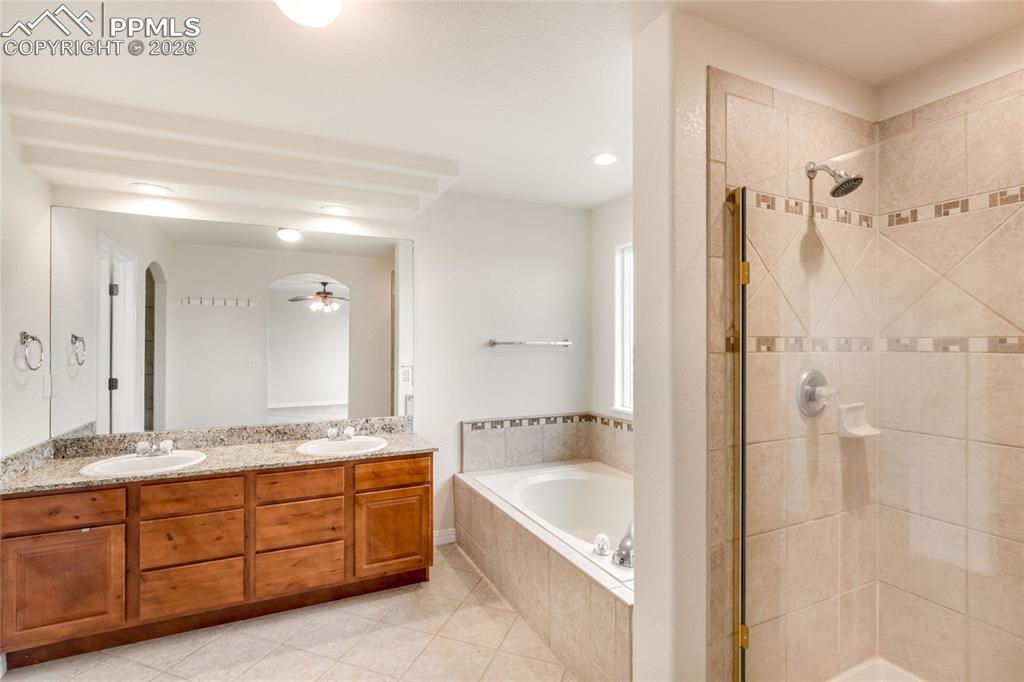 Image 21 of 35: 5 piece primary bathroom with soaking tub and entrance to walk-in closet.