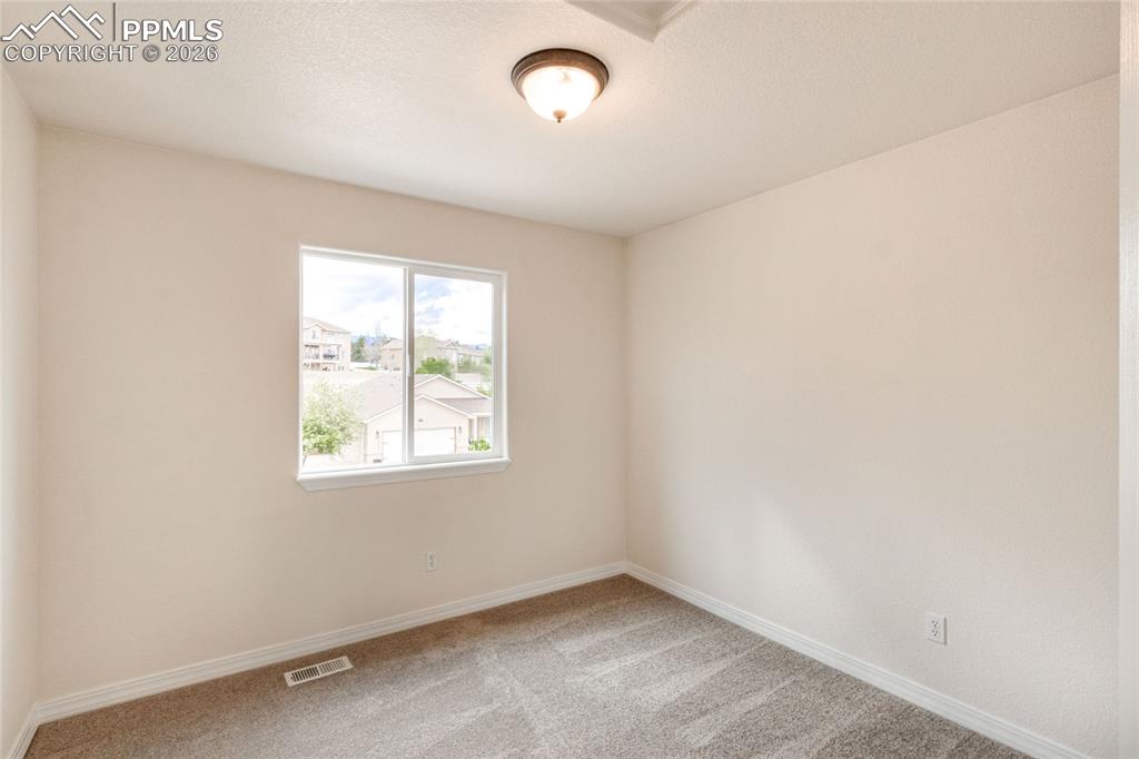 Image 23 of 35: First upstairs bedroom with white walls and a closet with sliding doors