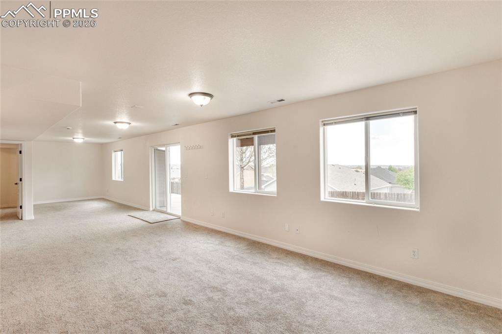 Image 26 of 35: Spacious basement bonus room featuring neutral carpeting, light-toned walls