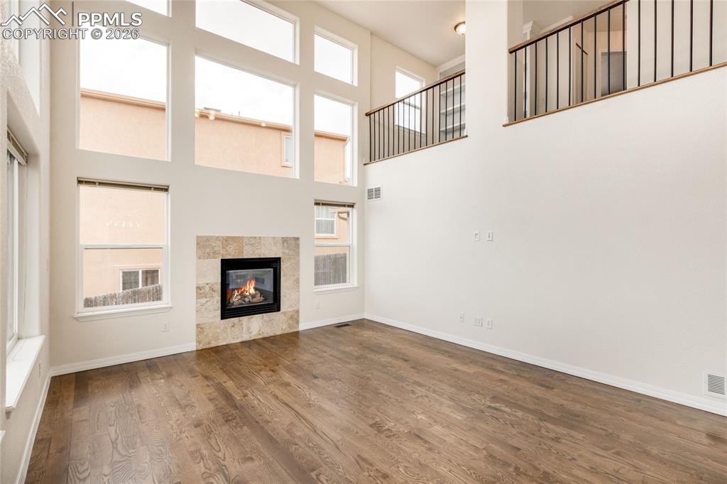 Image 3 of 35: Two-story living area with expansive windows, wood-look flooring, and view