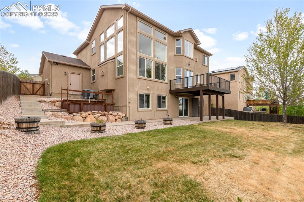 Image 32 of 35: Multi-level exterior featuring a stucco facade, an upper-level deck with bl