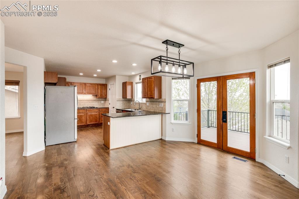 Image 6 of 35: Spacious open-concept kitchen and breakfast area featuring wood-finish floo