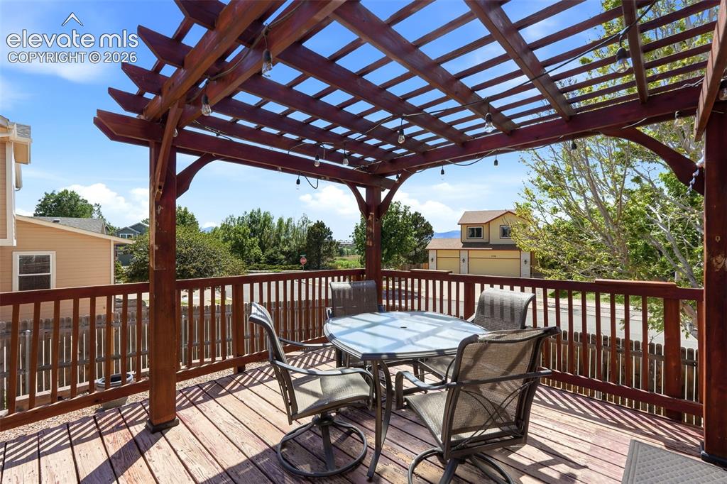 Image 18 of 32: Expansive wooden deck featuring a slatted pergola