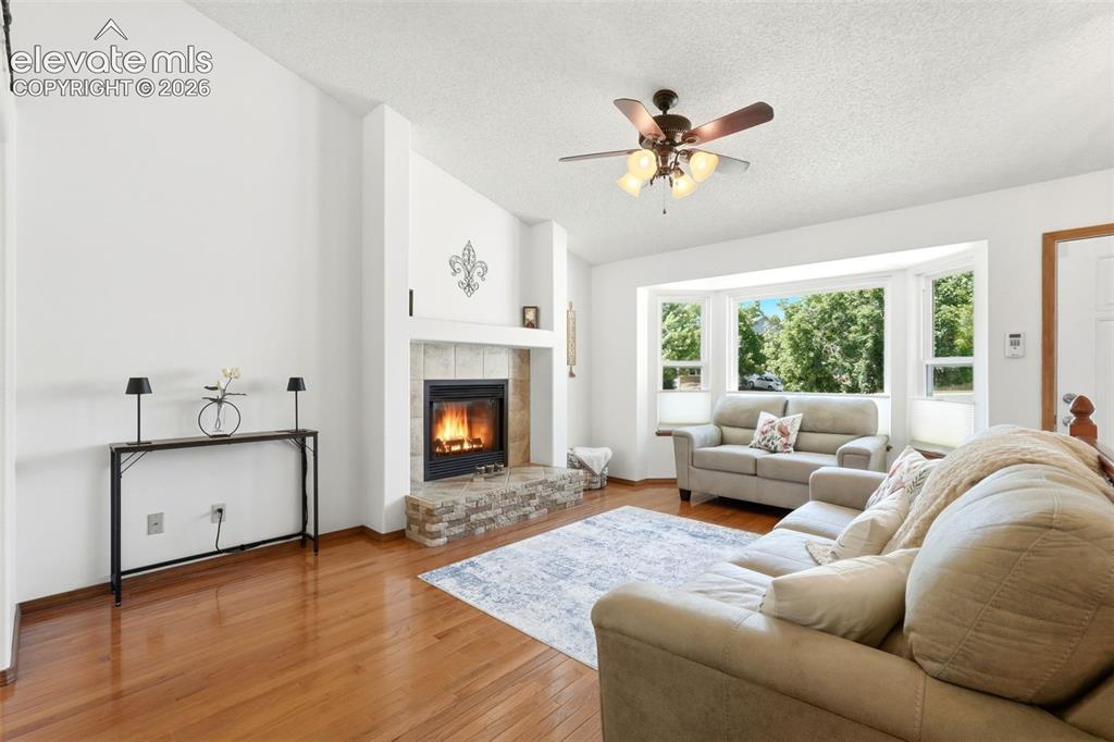 Image 3 of 32: Living area featuring a floor-to-ceiling fireplace with a tiled surround an
