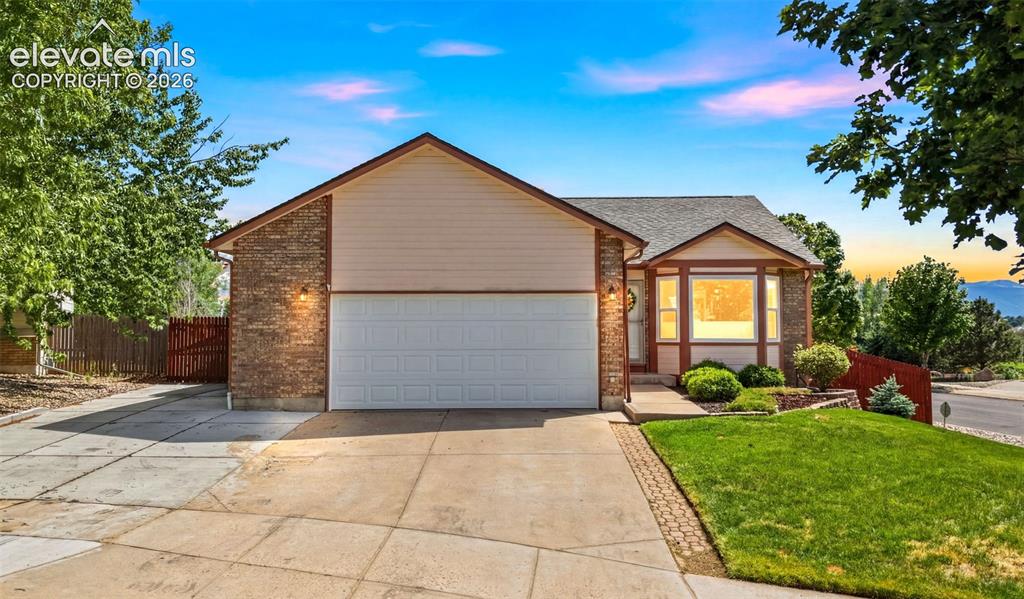 Image 30 of 32: Ranch-style residence featuring a brick facade, attached two-car garage, an