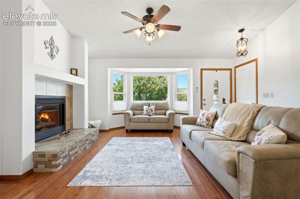 Image 4 of 32: Living area featuring wood-finish flooring and a white vaulted ceiling