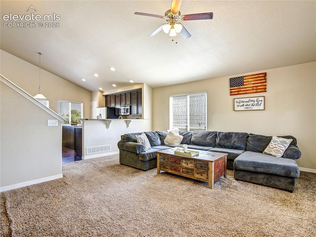 Image 10 of 39: The living room is open to the kitchen and family room