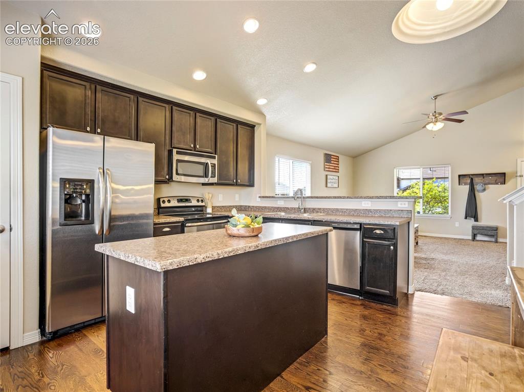 Image 13 of 39: Central island & pantry provide extra storage & make this a great space for