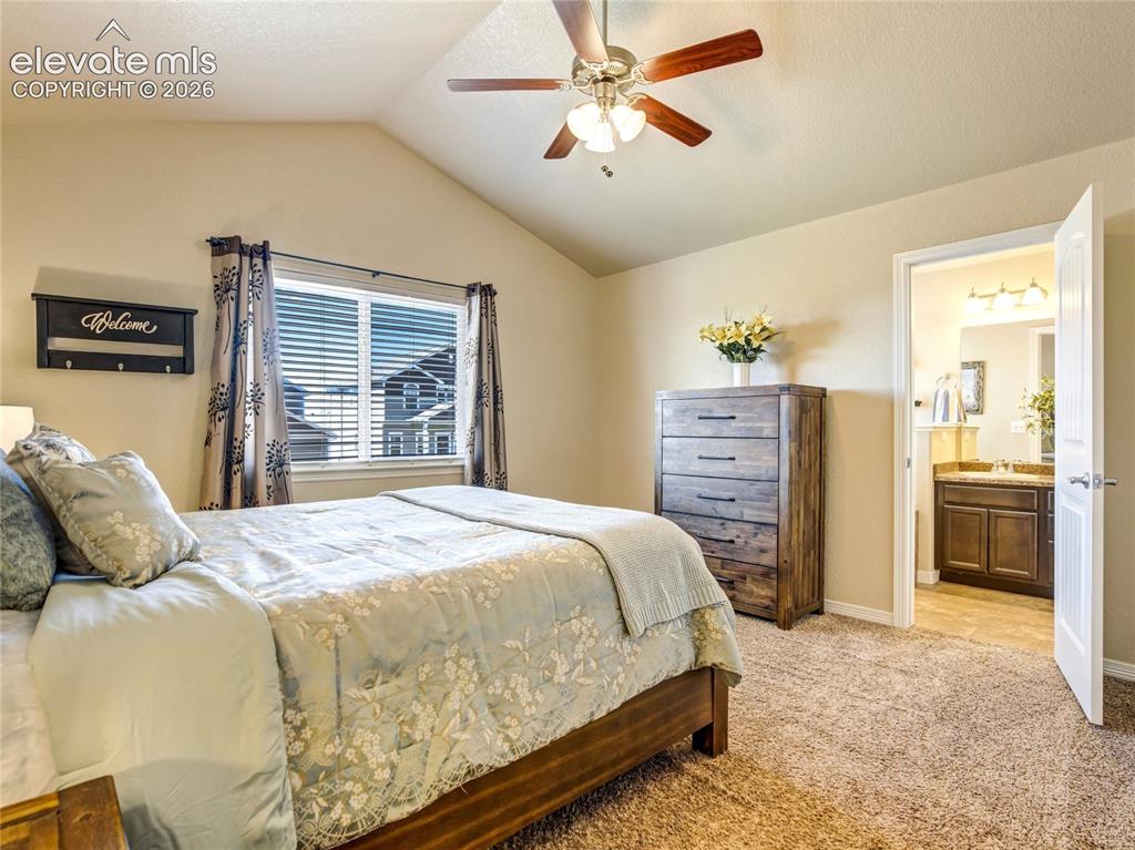 Image 21 of 39: Primary bedroom with ceiling fan and en-suite