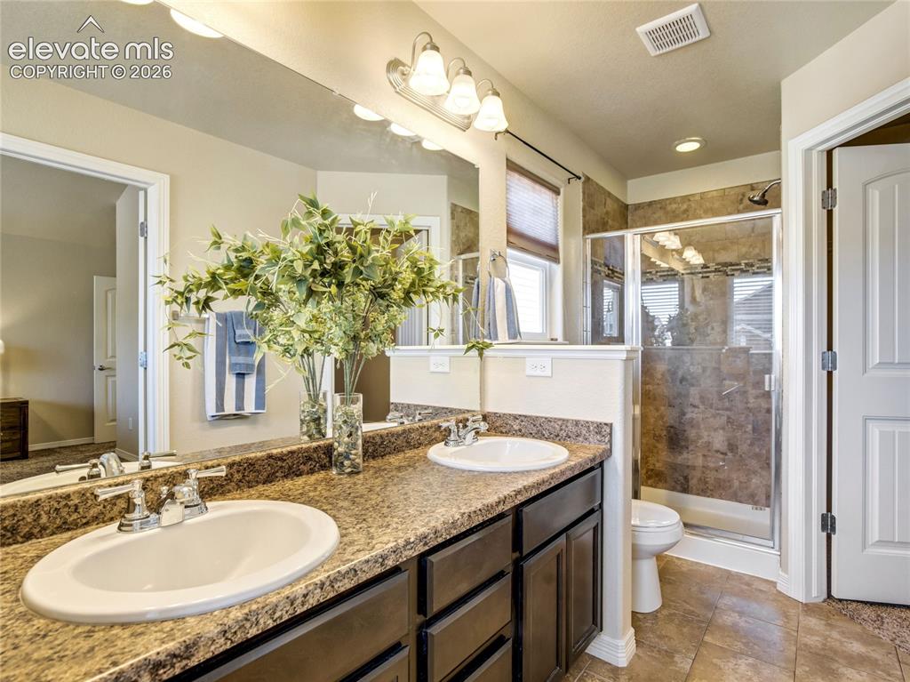 Image 5 of 39: Primary en-suite with double vanity & glass walled shower