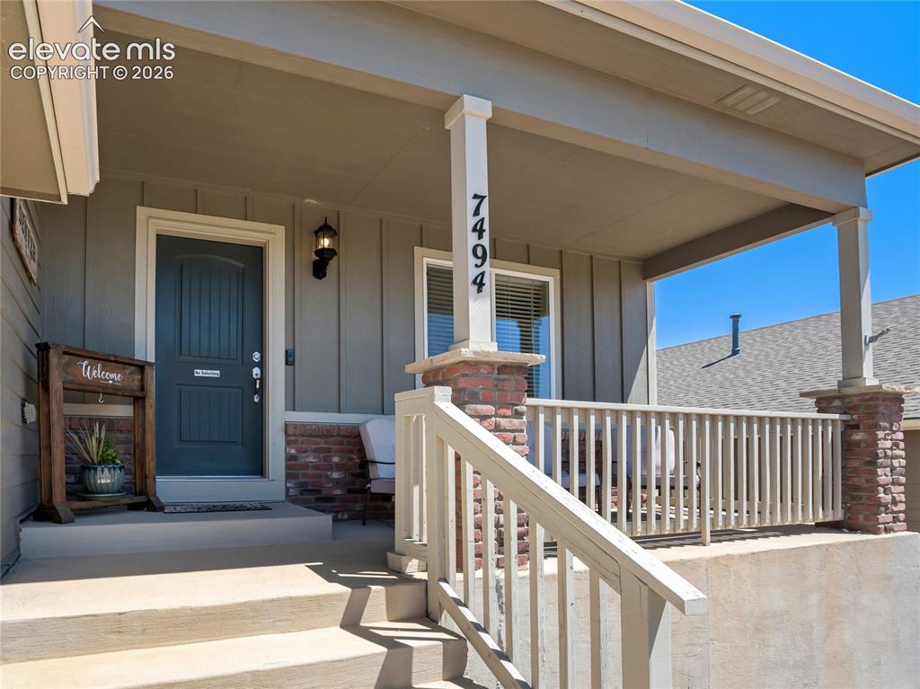Image 7 of 39: A covered front porch offers curb appeal & charm, an added bonus in Colorad