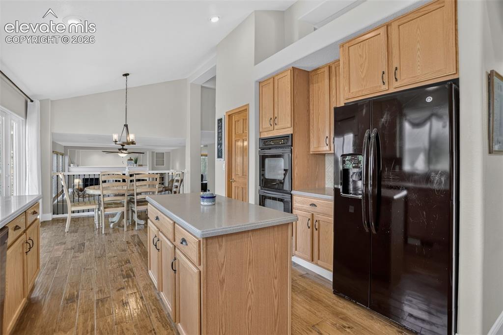 Image 16 of 49: Kitchen featuring wood-finish flooring, a central island with countertop, n