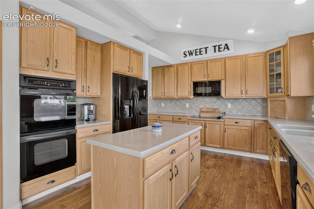 Image 17 of 49: Spacious kitchen featuring light wood cabinetry, a center island with count