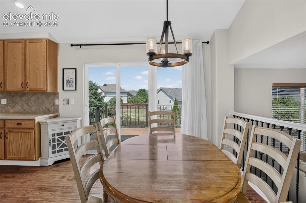Image 19 of 49: Dining area featuring wood-finish flooring, a contemporary chandelier, and 