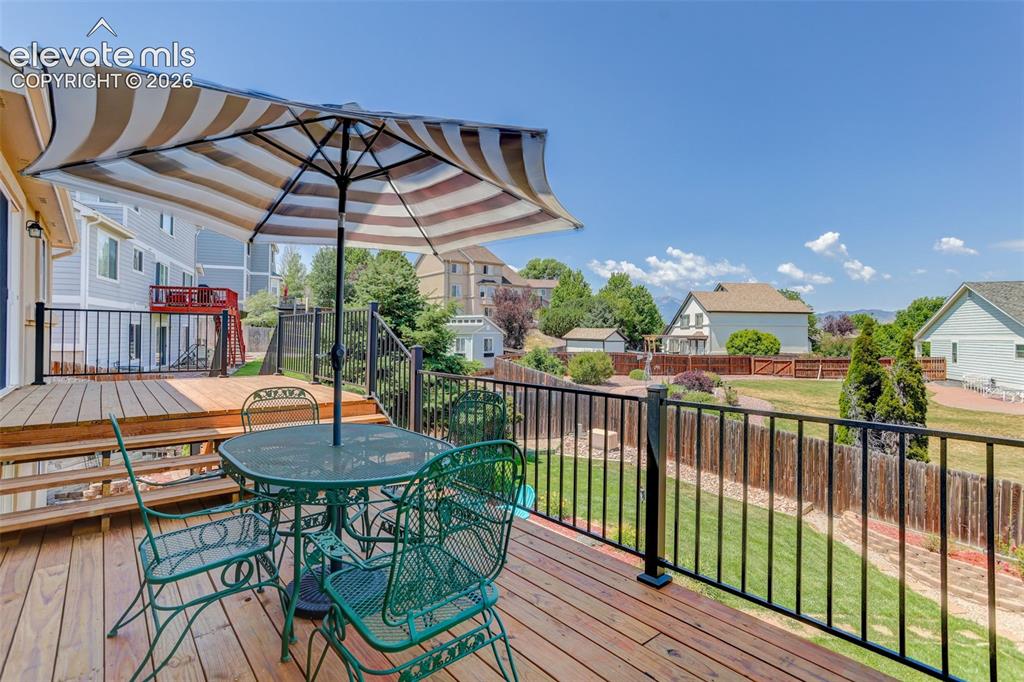 Image 2 of 49: Multi-level wood deck featuring black metal railings and a tiered design