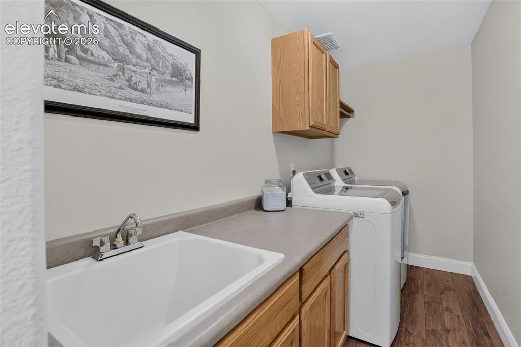 Image 27 of 49: Laundry area featuring a utility sink with chrome faucet, light wood-finish