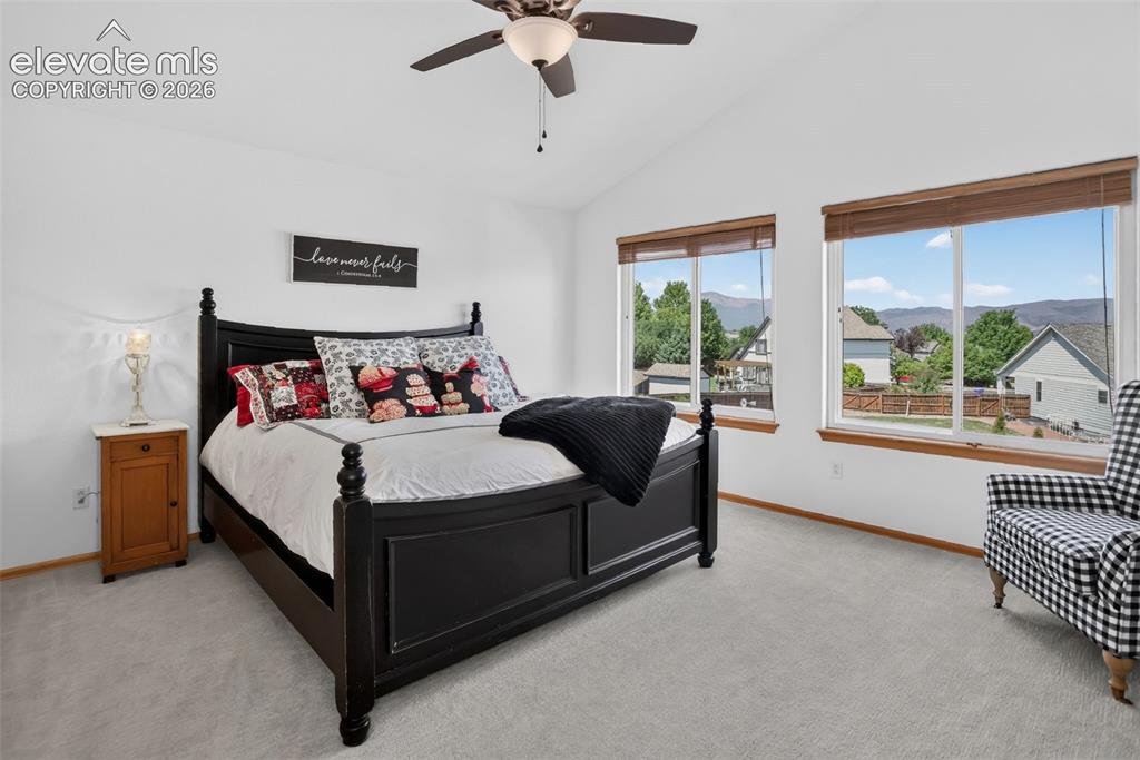 Image 28 of 49: Carpeted interior space featuring a vaulted ceiling with a ceiling fan