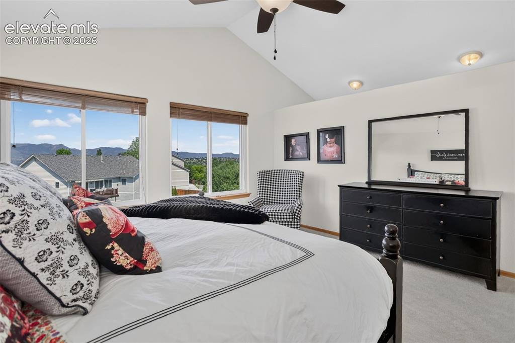 Image 29 of 49: Vaulted ceiling bedroom with large windows showcasing distant landscape