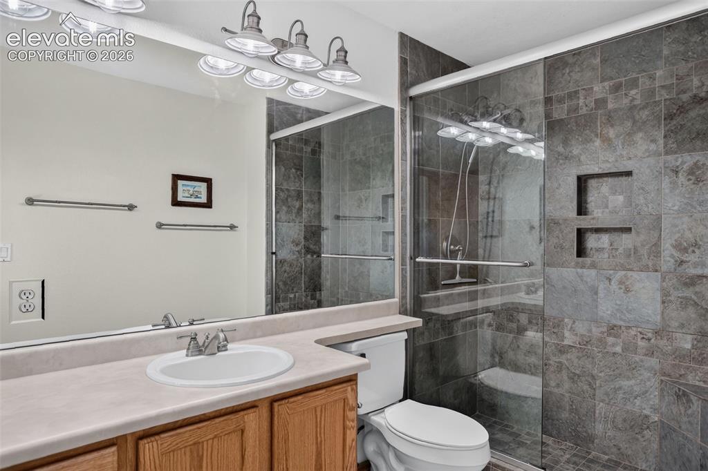 Image 36 of 49: Full bathroom featuring a walk-in shower with glass enclosure, integrated s