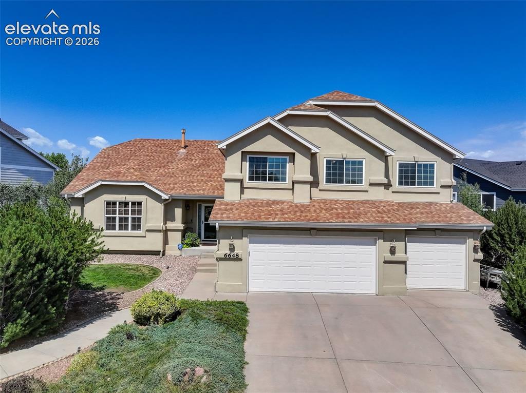 Image 4 of 49: Stucco exterior residence featuring a multi-gabled shingle roof, attached t