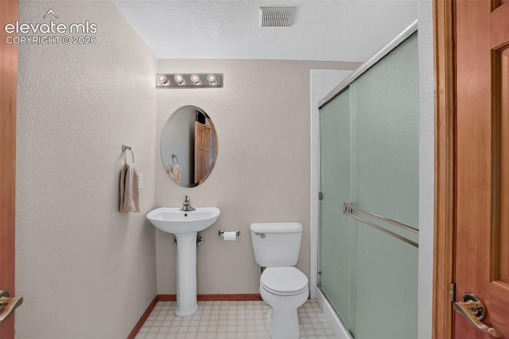 Image 43 of 49: Full bathroom featuring a pedestal sink, oval mirror, and a shower with fro