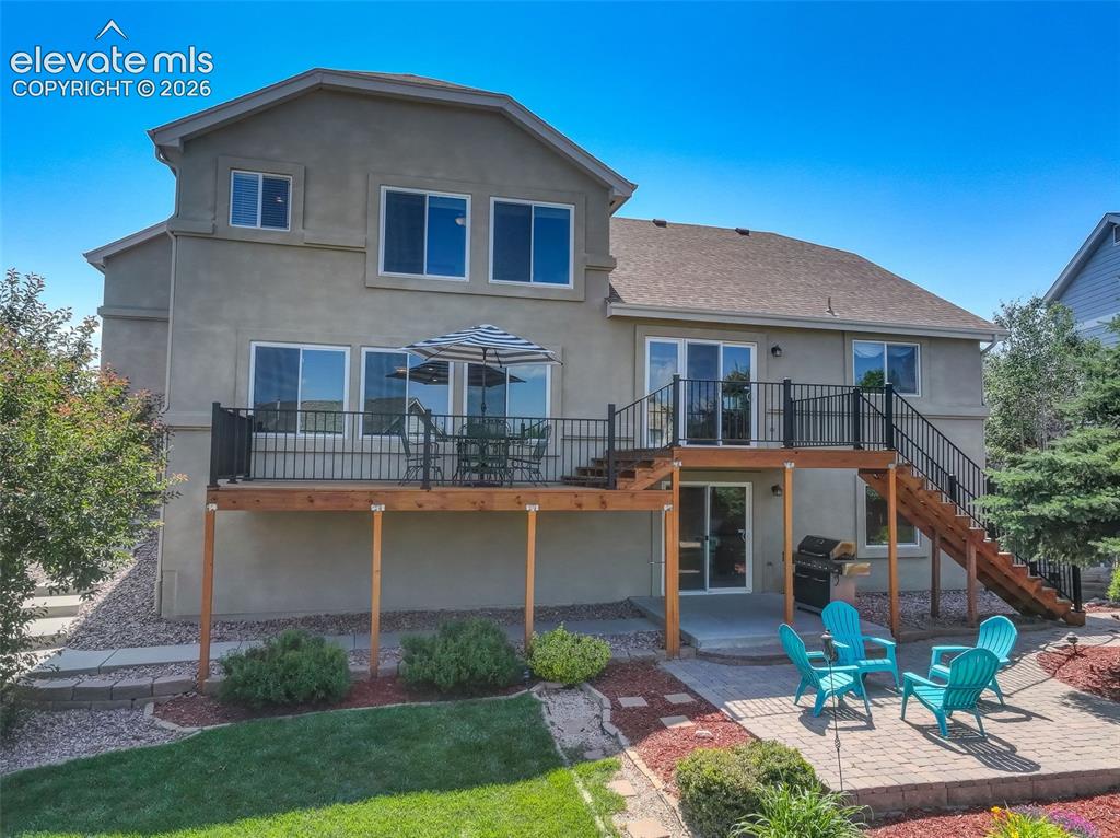 Image 49 of 49: Rear exterior with a multi-level deck featuring black metal railings and a 