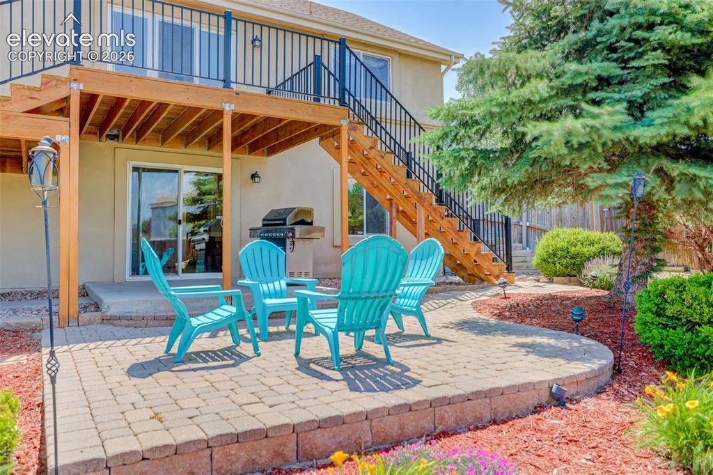 Image 7 of 49: Outdoor living space featuring a paver patio with a retaining wall, a multi
