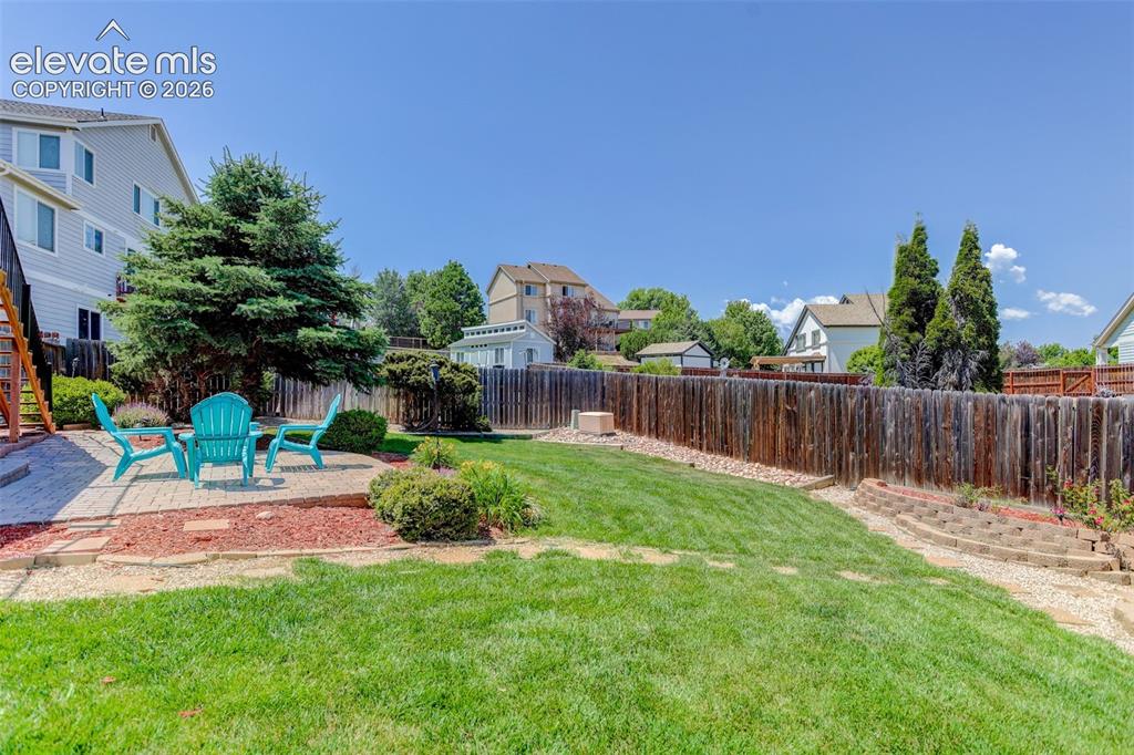 Image 8 of 49: Expansive backyard featuring a paver patio area, a wood privacy fence, a ma