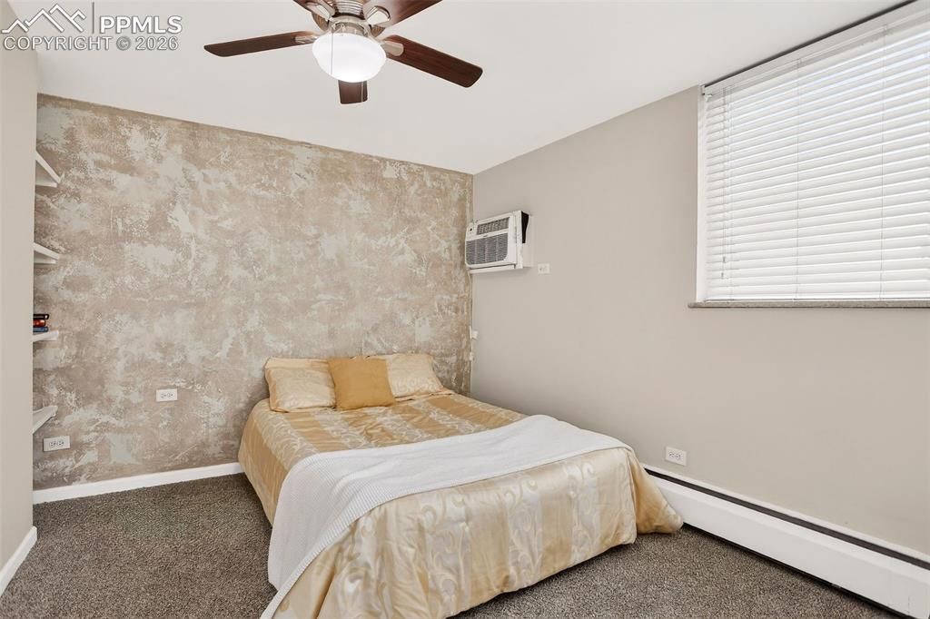 Image 10 of 25: Primary bedroom, air, ceiling fan, custom accent wall