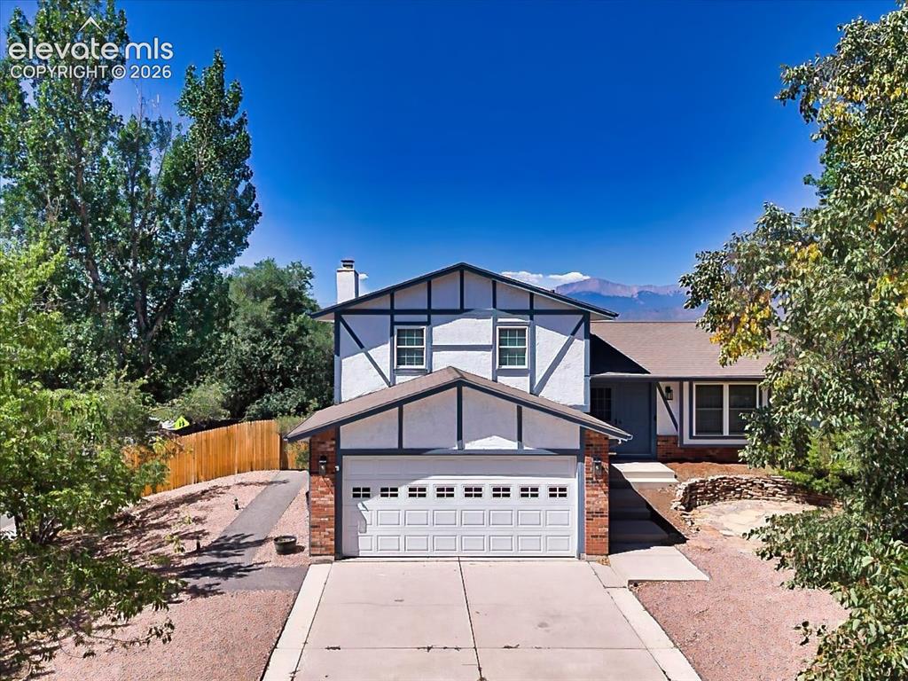 Image 1 of 50: Charming Tudor-inspired exterior with mature landscaping, an attached two-c