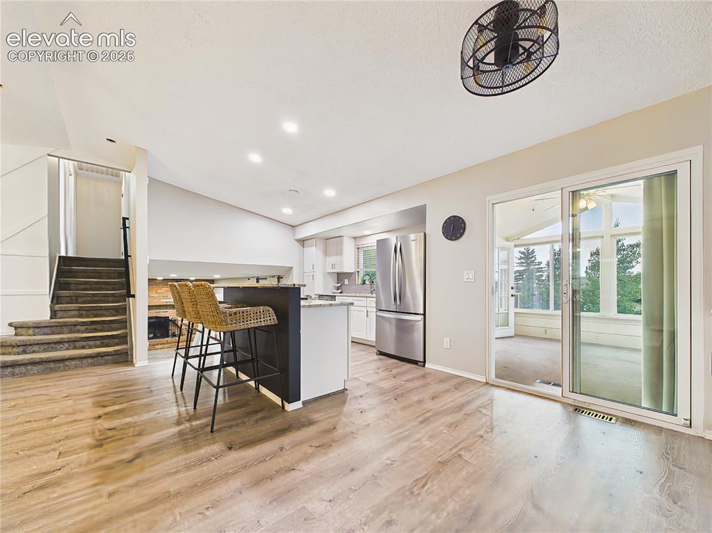 Image 13 of 50: Kitchen & Sunroom Access – Open kitchen layout with breakfast bar seating a